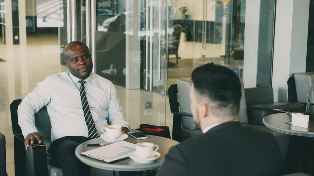 Two businessmen chatting across a table