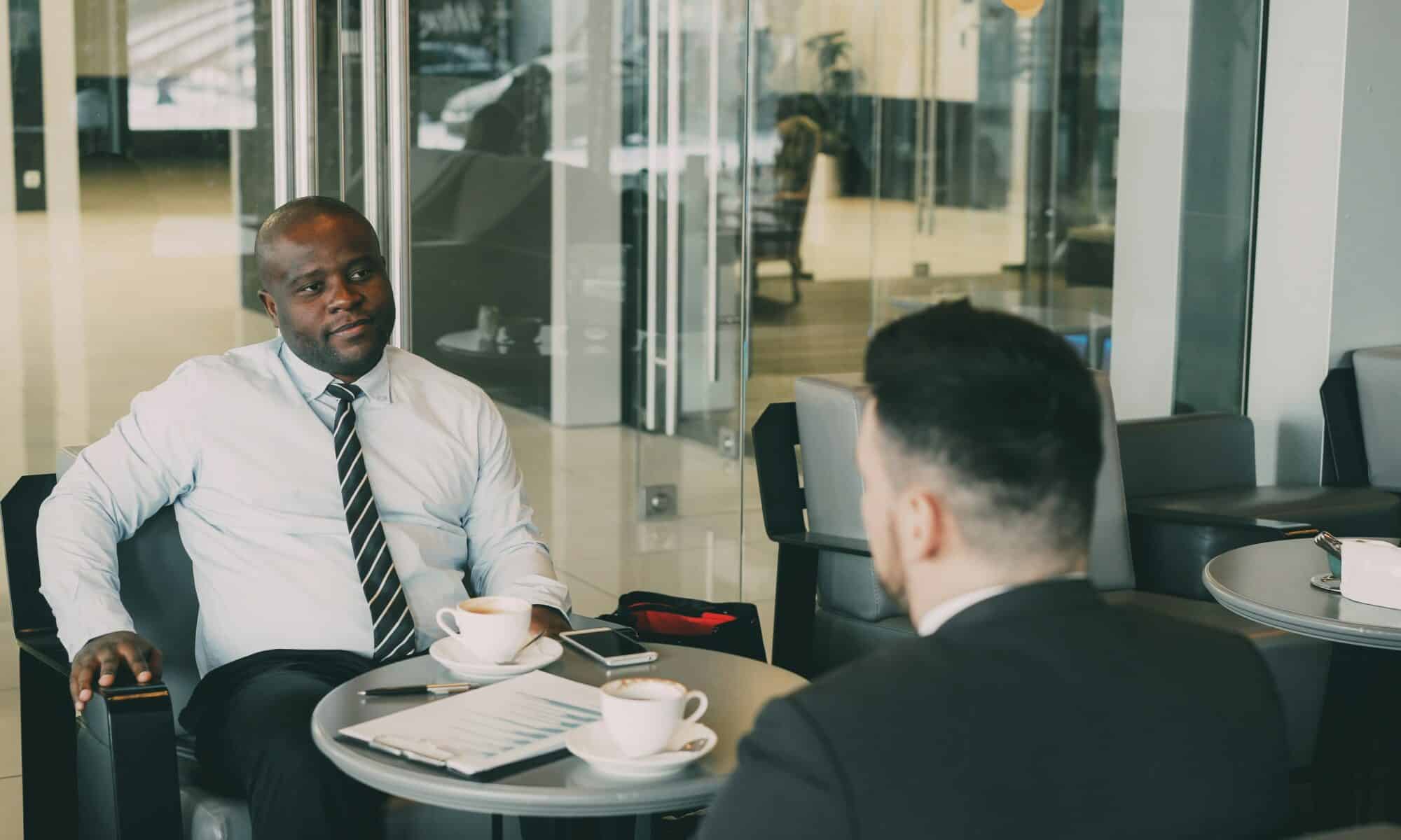 Two businessmen chatting across a table